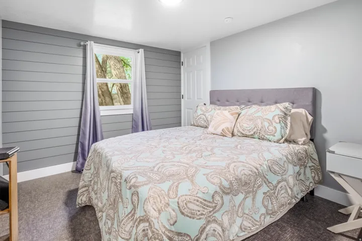 Horizontal plank wall accent, single window, white interior door, recessed ceiling lighting, and carpet flooring