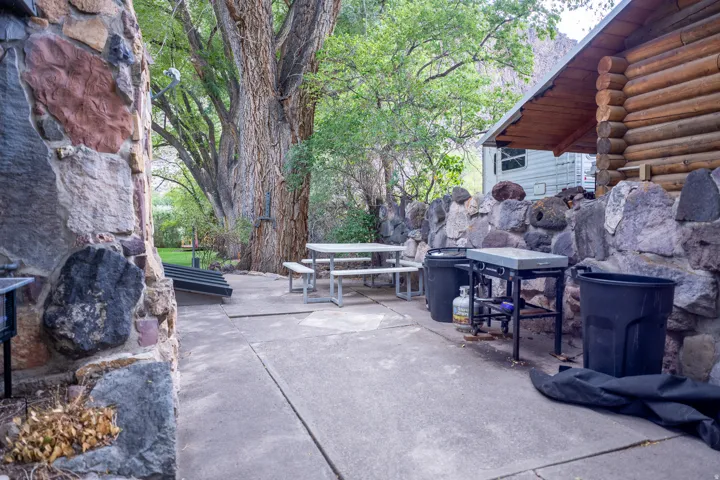 Concrete patio with a picnic table, complemented by a stone wall