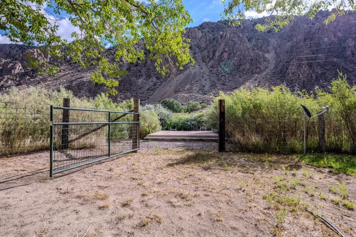 Rocky mountain backdrop with mature trees and established fencing