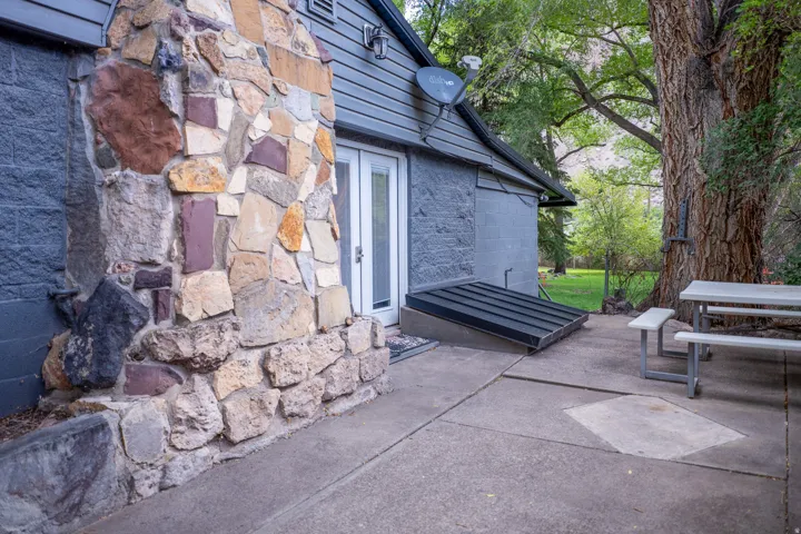 Full stone veneer exterior with a concrete patio