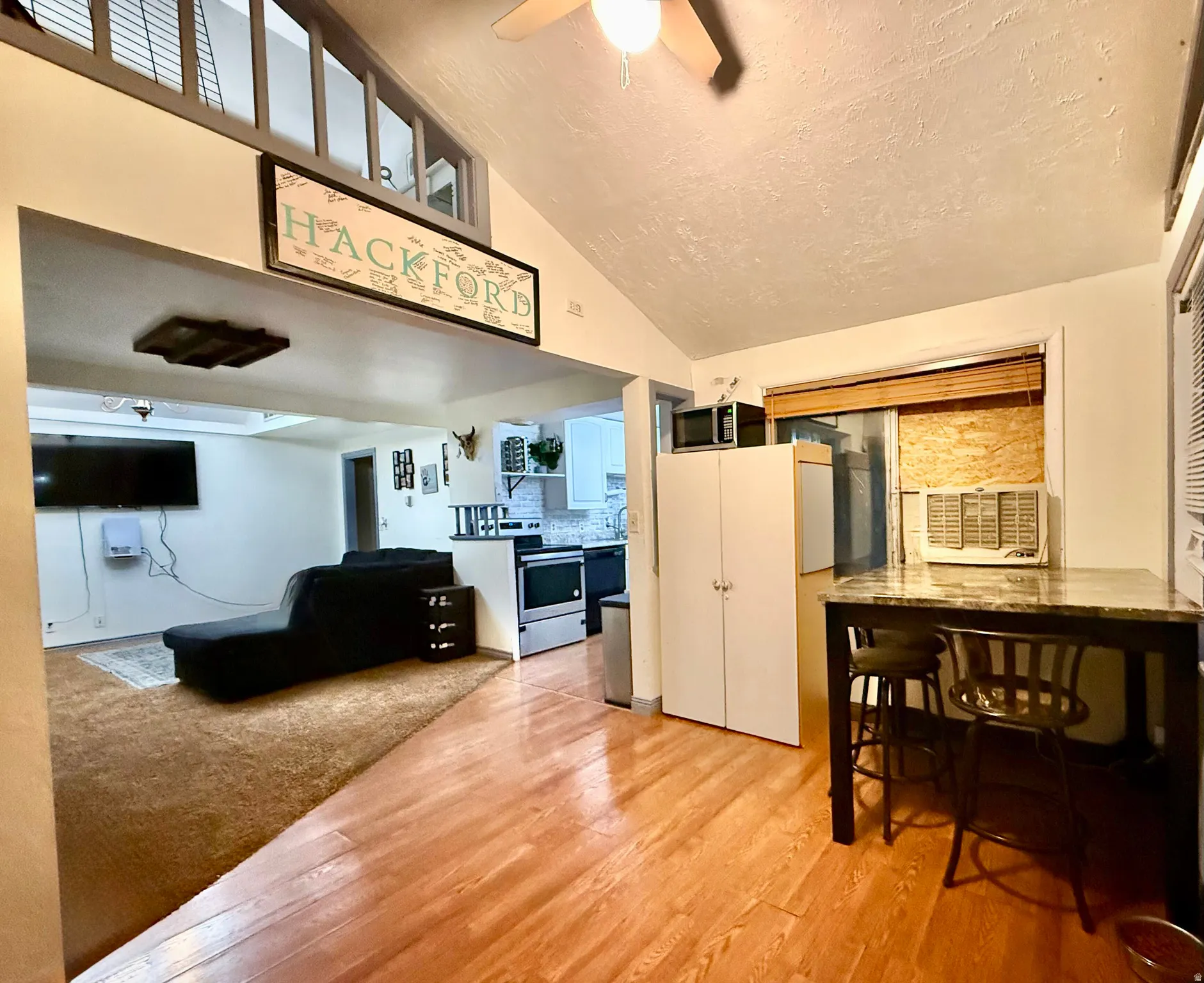 Wood-finish flooring, vaulted ceiling, and an elevated interior window