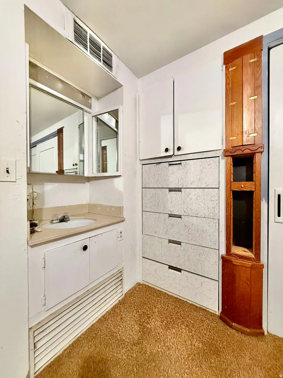 Built-in vanity with a sink, medicine cabinet, and overhead lighting