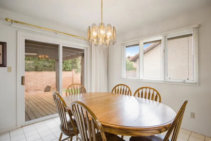 Recessed lighting, tiled flooring, an ornate chandelier, and a sliding glass door to the deck