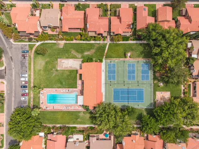 Community amenities featuring an outdoor swimming pool, multiple tennis courts, and expansive green spaces
