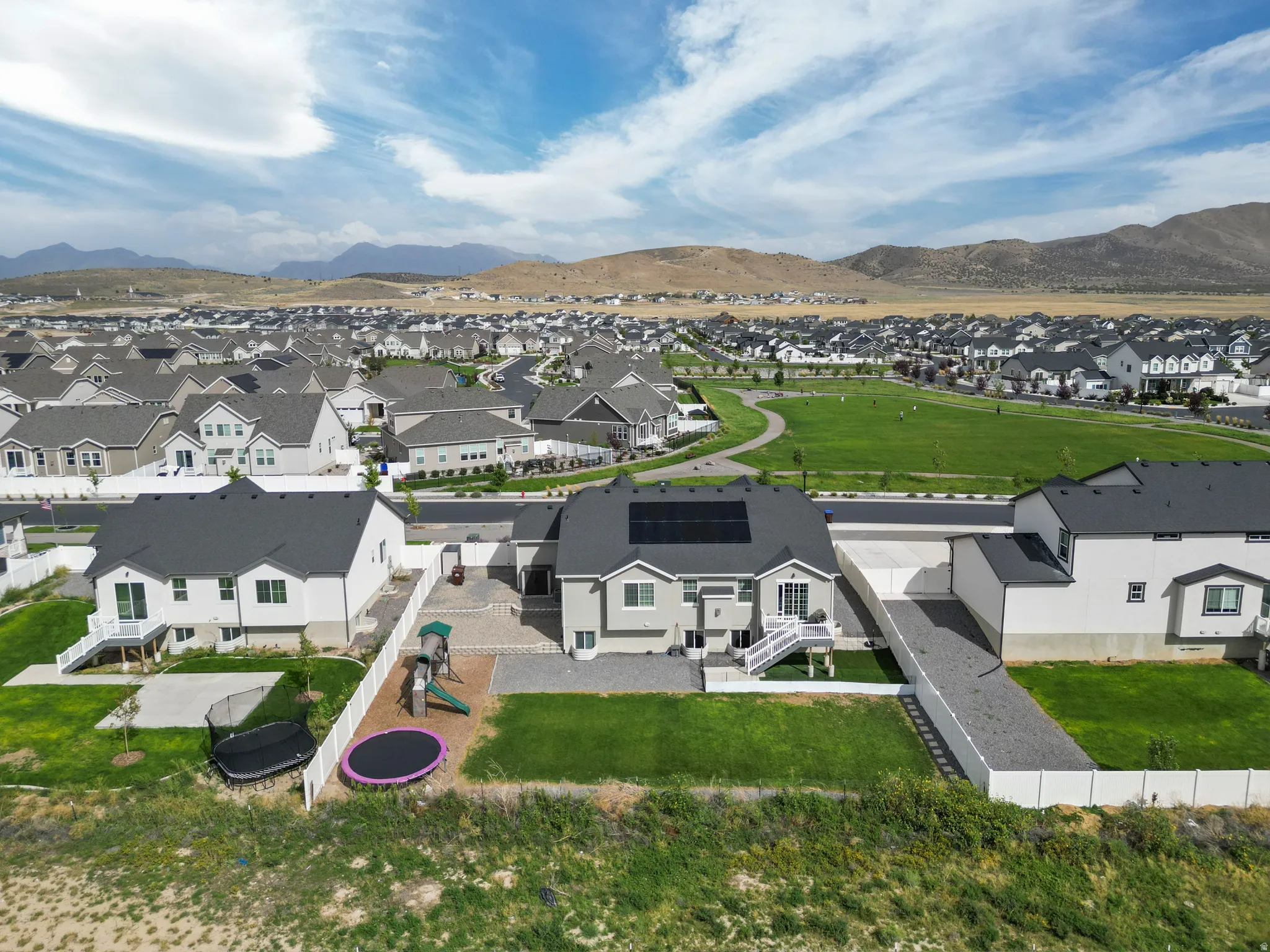 Expansive green spaces with paved pathways and mountain scenery