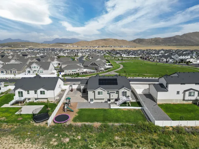 Expansive green spaces with paved pathways and mountain scenery