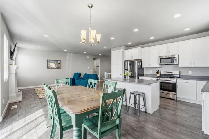 White cabinetry, stainless steel appliances, and a central island with bar seating