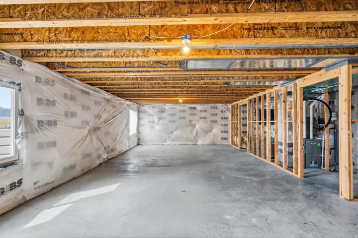 Unfinished basement with concrete flooring and exposed ceiling joists
