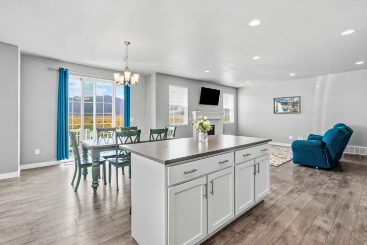Open-concept living space featuring wood-finish flooring, recessed lighting, and a kitchen island with storage