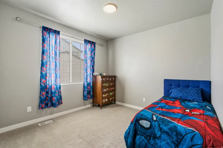 Light gray wall color, neutral carpet flooring, window with blinds, overhead flush mount lighting