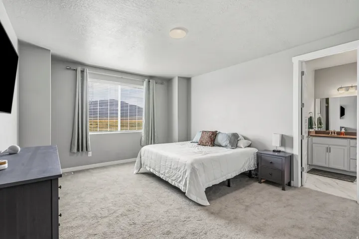 Wall-to-wall carpeting, recessed ceiling lighting, and a window with blinds and curtains