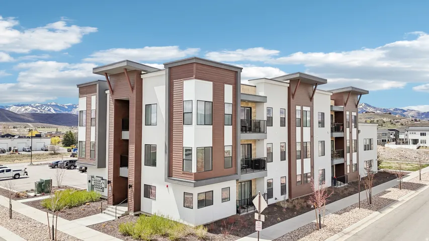 Contemporary multi-story building with a stucco and wood-finish exterior