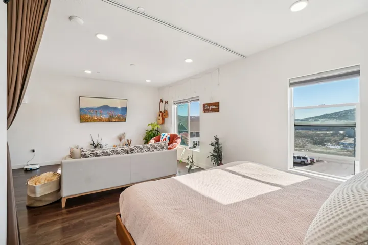 Open-concept living area with dark wood-finish flooring, recessed lighting, and large windows