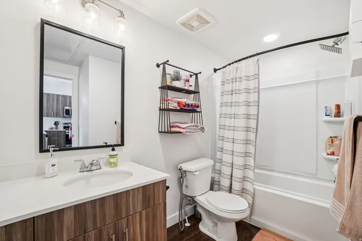 Bathroom featuring a single vanity with wood-finish cabinetry, a white countertop, and an undermount sink
