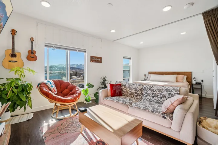 Bright living space featuring dark wood-finish flooring, recessed lighting, and a large window