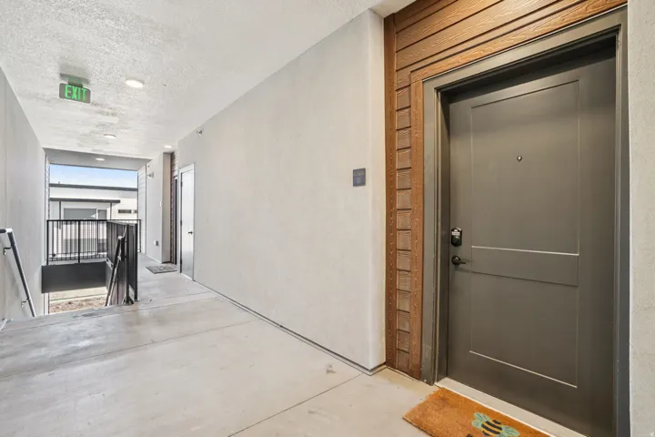 Private entry door with decorative wood-finish trim, concrete flooring, and recessed ceiling lighting