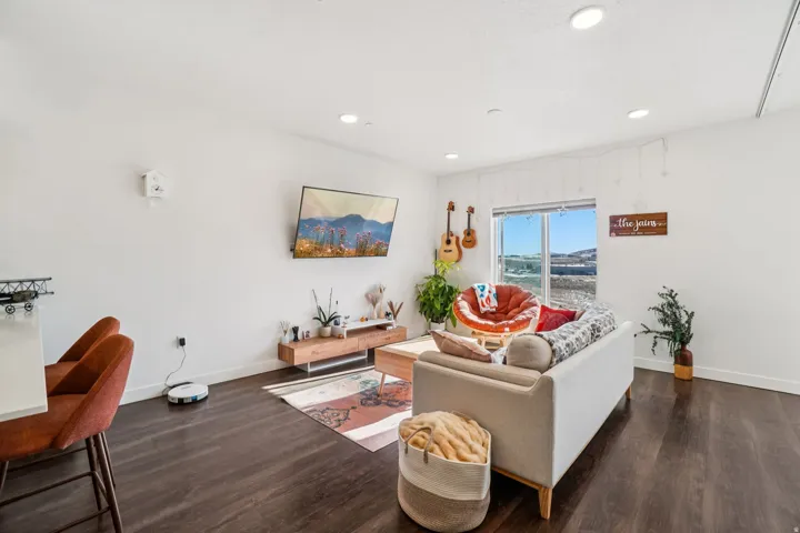 Recessed lighting, wood-finish flooring, and a large window providing ample natural light