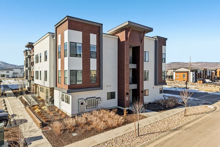 Modern exterior with multi-tone siding, wood-finish paneling, and dark-framed windows