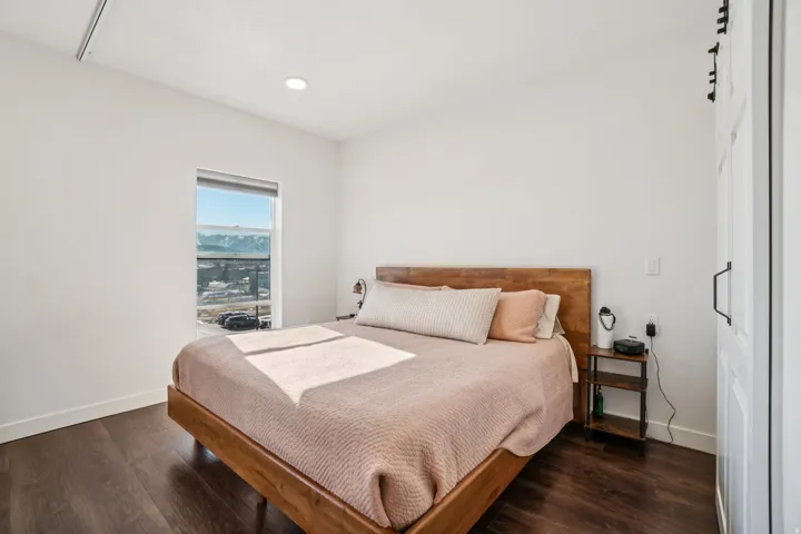 Wood-finish flooring, recessed lighting, a window with mountain scenery, and a barn door with black hardware