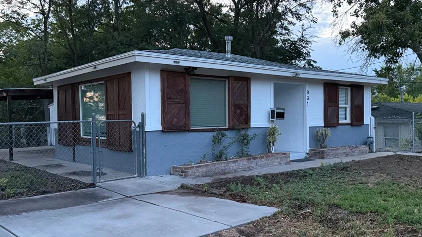 White exterior with a gray foundation, wood-finish shutters, and a front porch