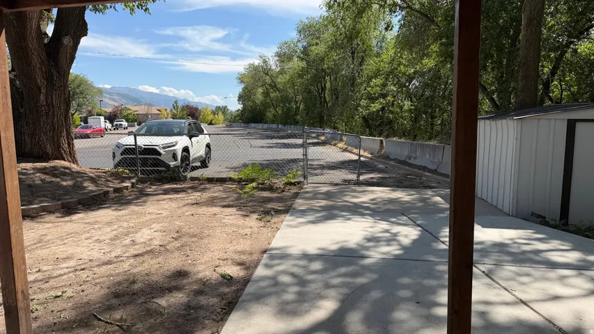 Concrete walkway and a white metal storage shed