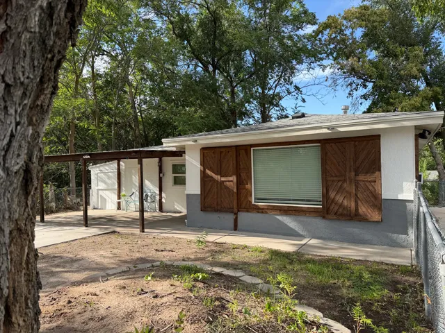 Stucco exterior with wood-finish shutters and a covered patio
