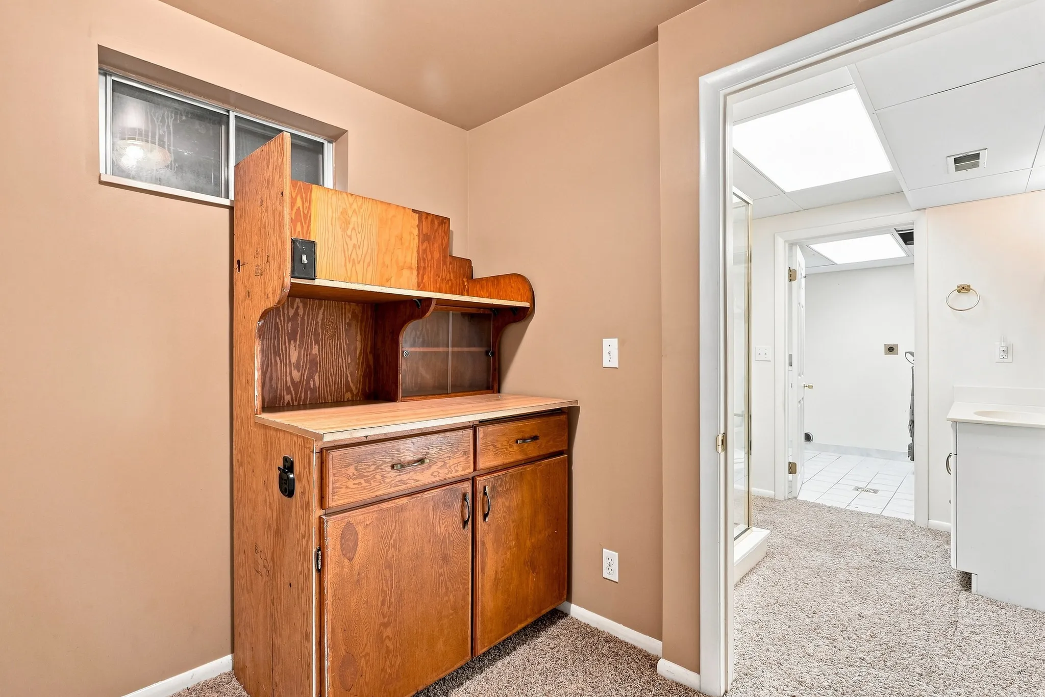 Built-in wood-finish cabinetry featuring upper shelving and lower storage