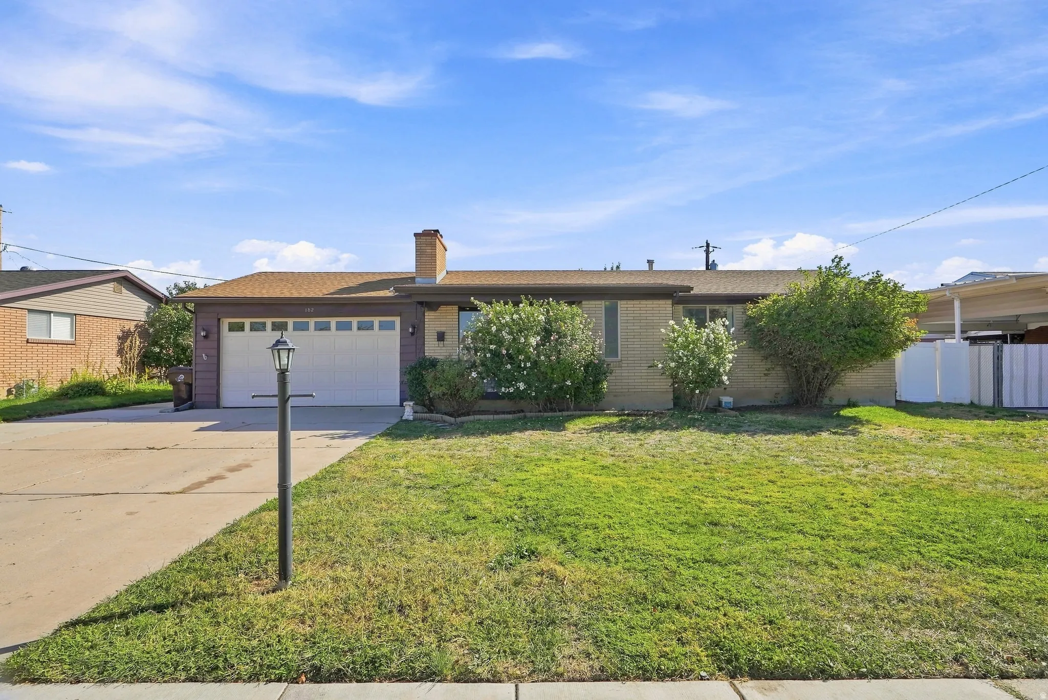 Single-story residence featuring a brick facade, attached two-car garage, and a concrete driveway