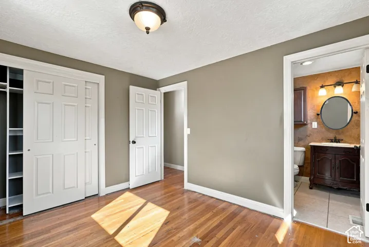 Hardwood flooring, sliding closet doors with built-in shelving, panel interior doors, and a flush mount ceiling light