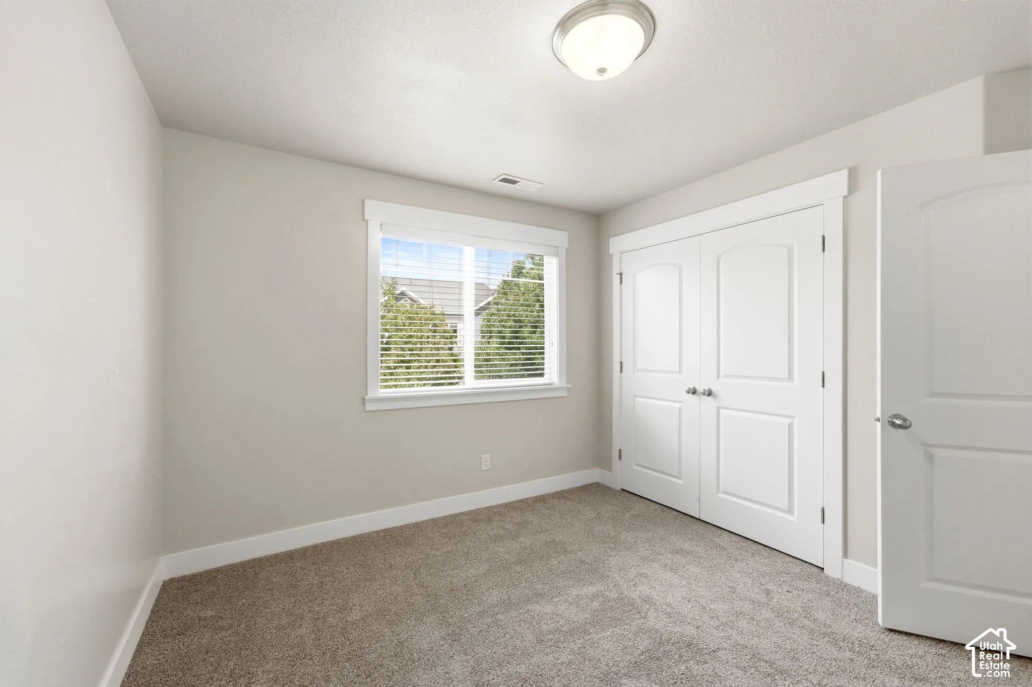 Recessed lighting, neutral wall tones, carpeted flooring, window with blinds, and white trim