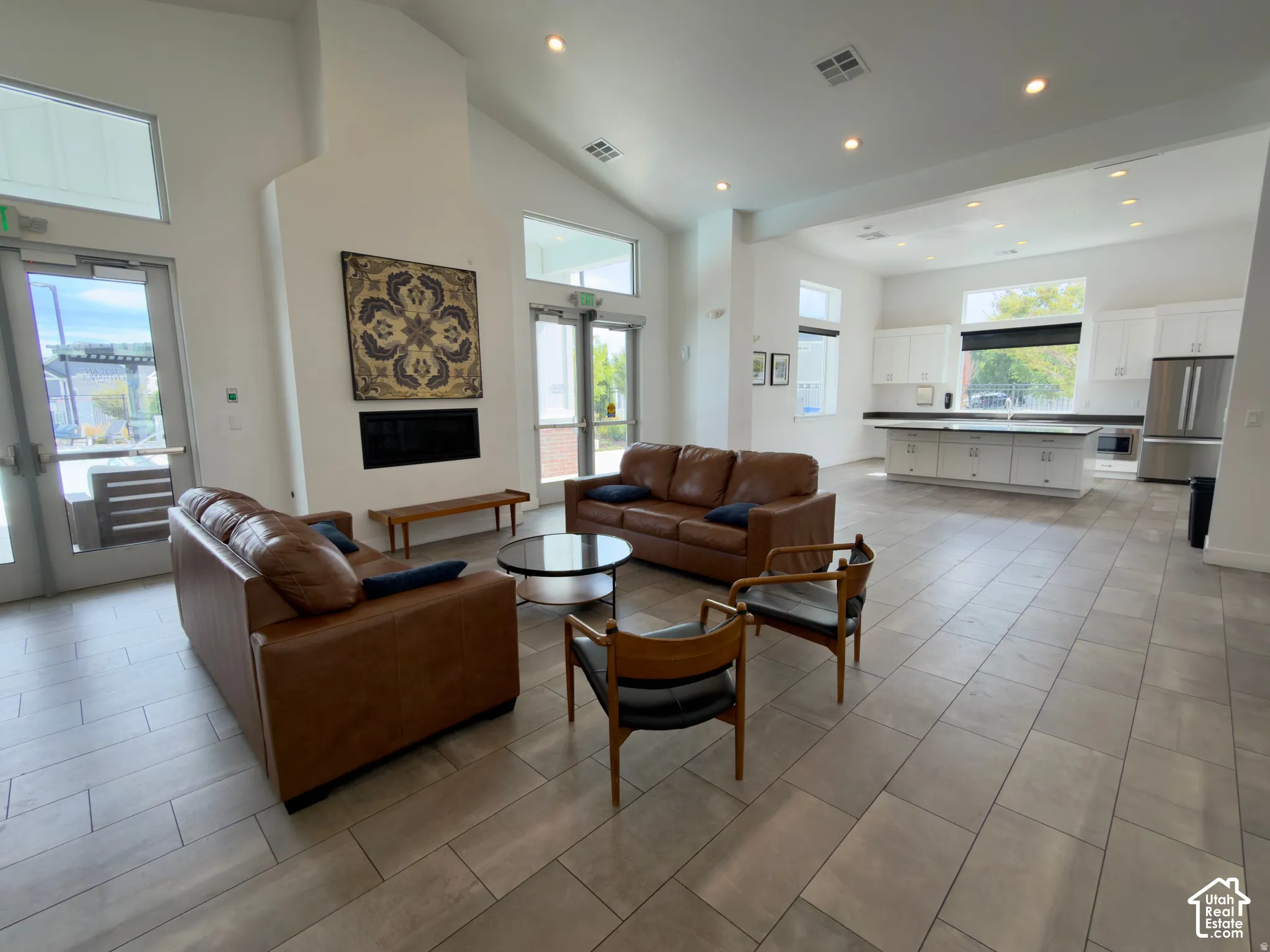Vaulted ceilings, recessed lighting, and tile flooring define this spacious open-concept area