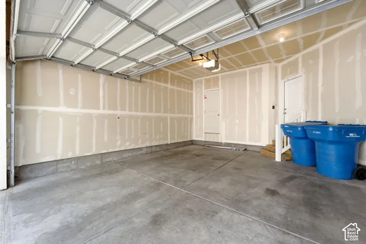 Concrete flooring, overhead garage door, built-in lighting, interior access door, white trim