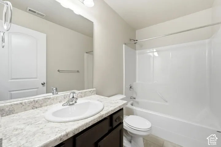 Integrated vanity with a white oval sink, speckled countertop, and dark wood-finish cabinetry
