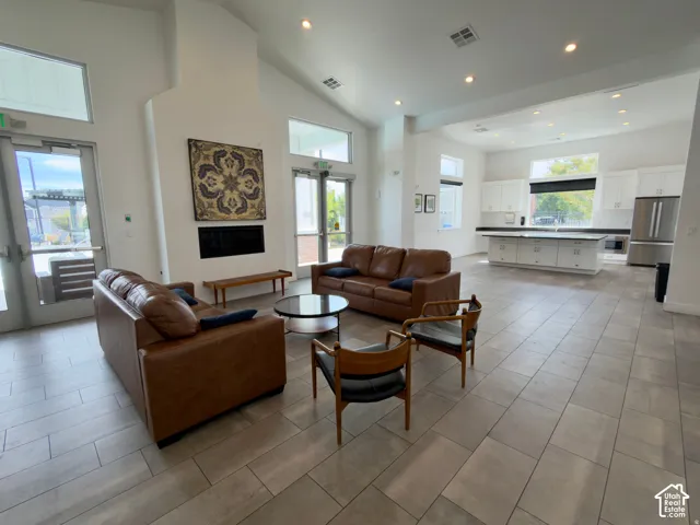 Vaulted ceilings, recessed lighting, and tile flooring define this spacious open-concept area