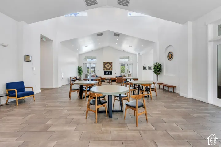 Tile flooring with a herringbone pattern, vaulted ceilings, recessed lighting, skylights, and double glass doors