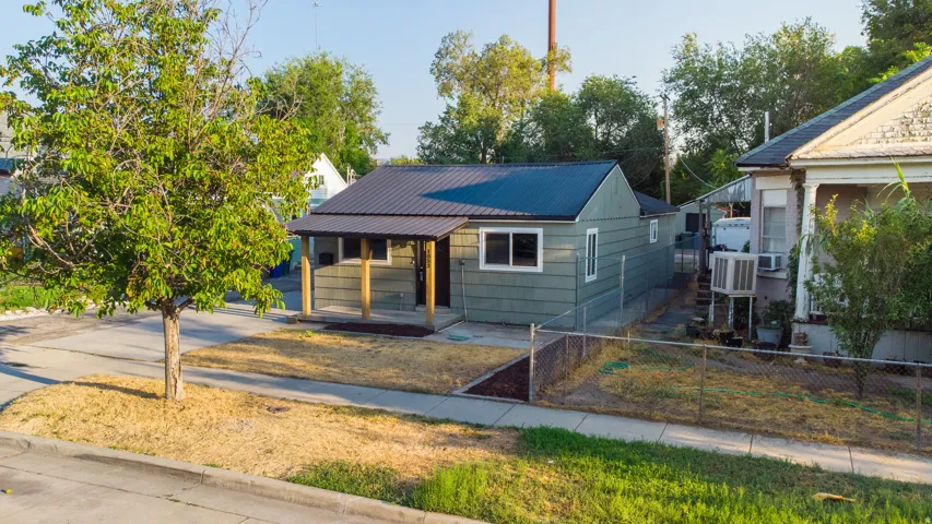 Exterior featuring horizontal siding, a metal roof, a covered porch with wood posts, and a front walk