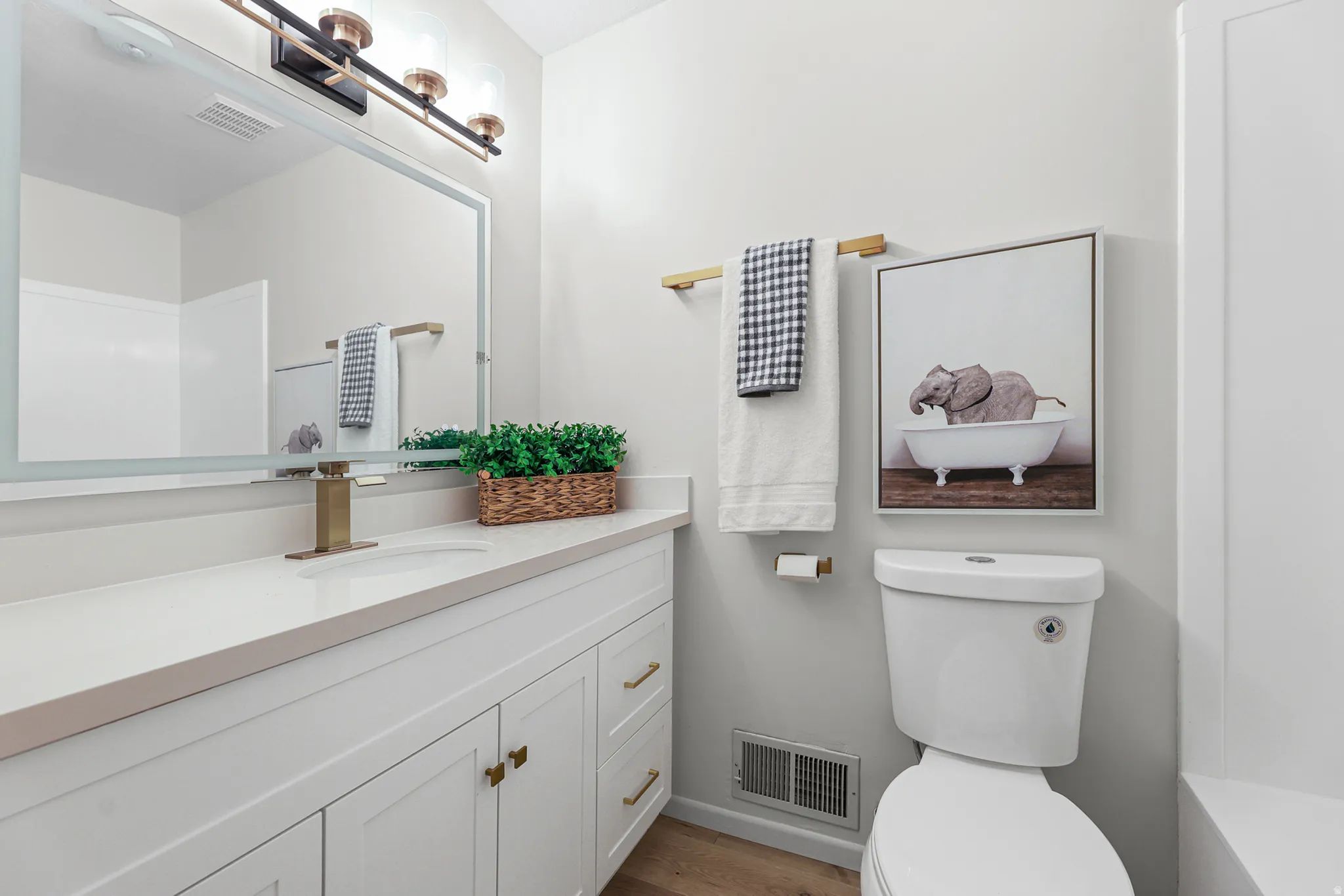 Vanity with white cabinetry, a single basin sink, and a light-toned countertop