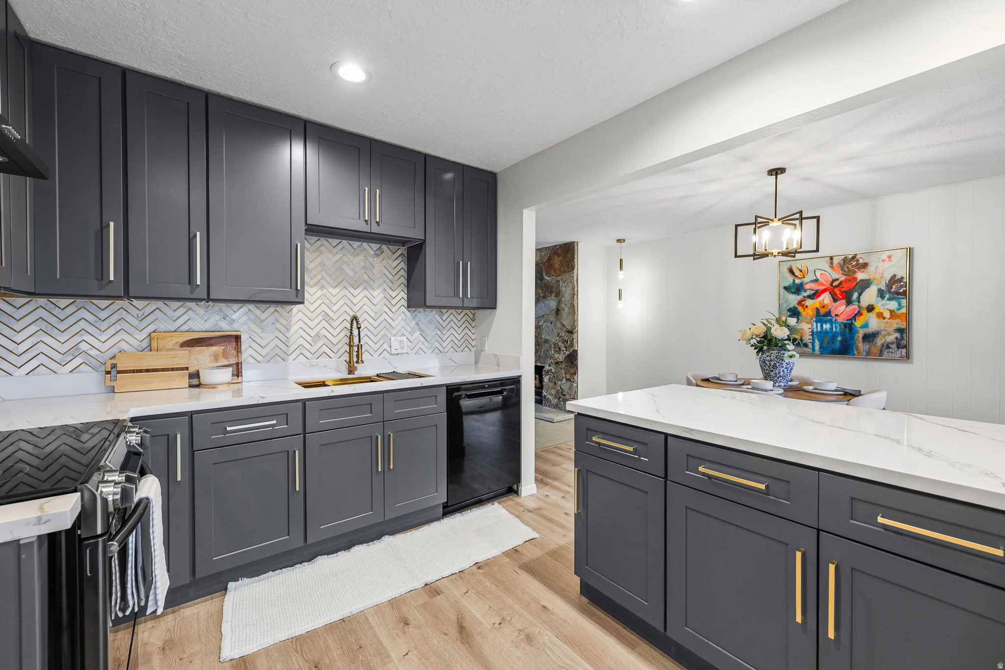 Kitchen featuring dark grey shaker cabinetry, white countertops, chevron tile backsplash, and wood-finish flooring