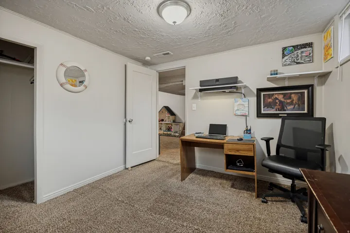 Carpeted interior space with white walls, a visible doorway, and an open closet