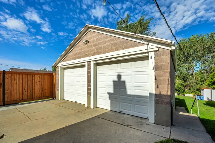 Two-car garage with block construction, white garage doors, and a concrete driveway