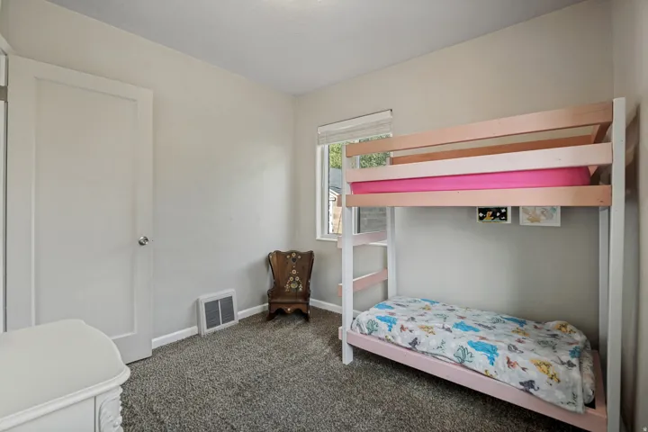 Carpeted flooring, neutral wall paint, white trim, and a window with natural light