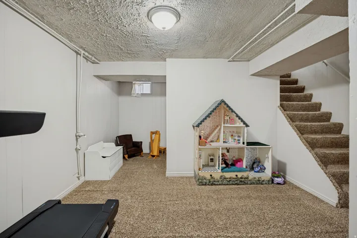 Carpeted flooring, painted walls, and ceiling-mounted lighting