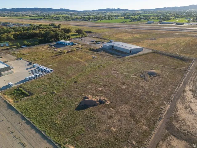 Expansive lot with multiple structures, including a large industrial-style building and smaller outbuildings