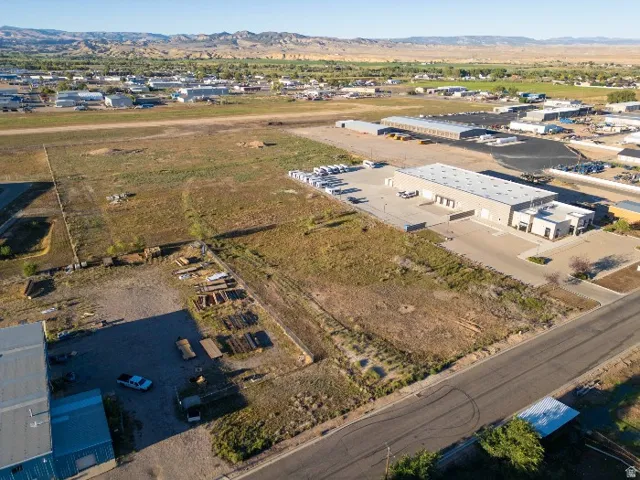 Expansive land parcel with surrounding developed properties and distant mountain backdrop