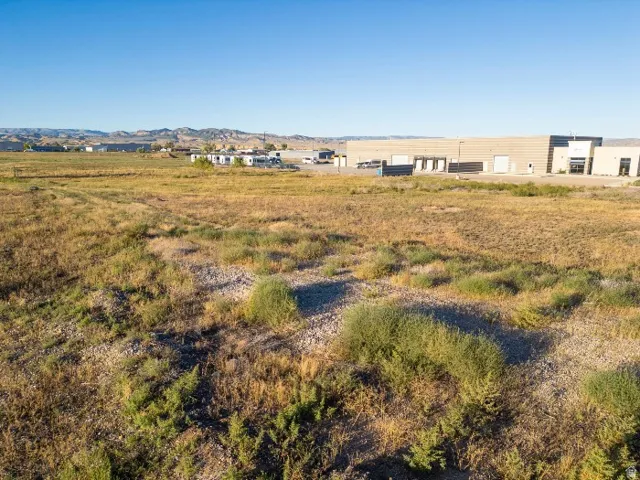 Expansive undeveloped land featuring natural vegetation and distant commercial structures