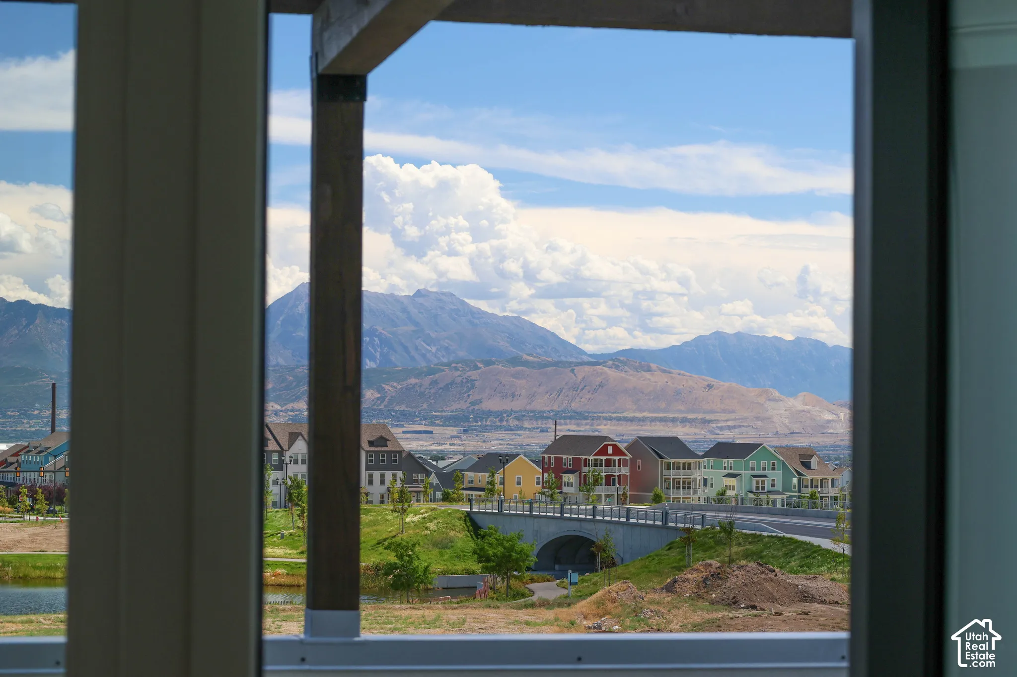 View from Primary bedroom-Balcony of Mountain backdrop, residential development, serene water feature, modern bridge, distant structures