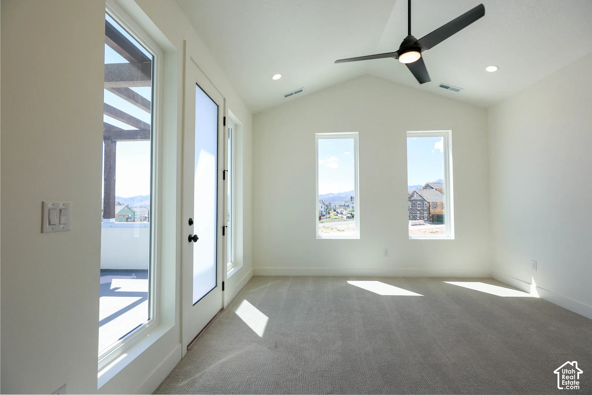 Primary bedroom with access to Balcony and Vaulted ceiling with an integrated ceiling fan and recessed lighting