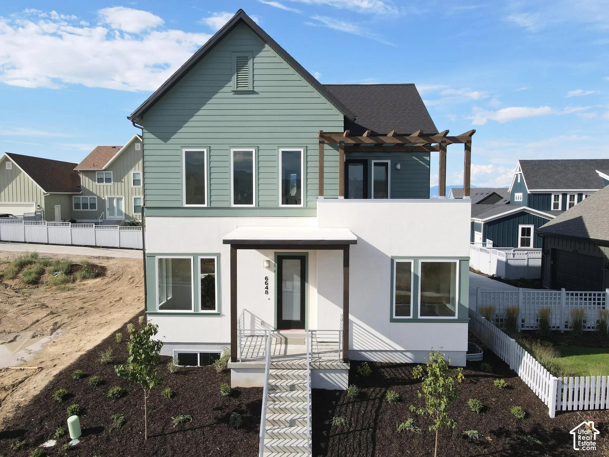 Modern exterior with a light green and white color palette, featuring a dark roof