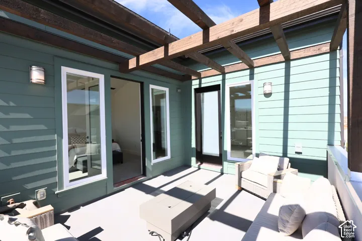 Expansive outdoor patio with a wooden pergola, light green siding, and a white railing