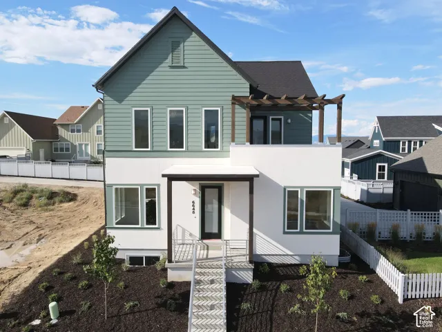 Modern exterior with a light green and white color palette, featuring a dark roof